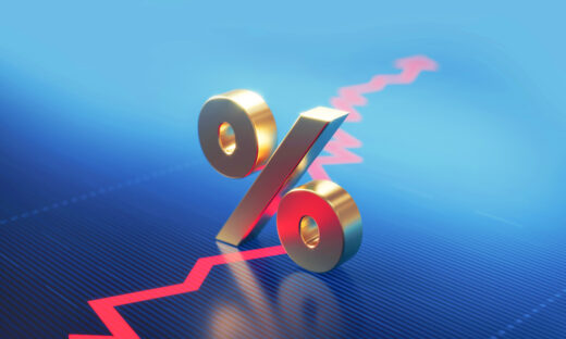 Percentage sign standing over a financial graph