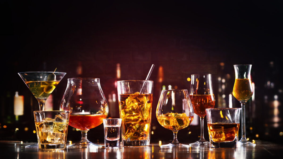 Assortment of hard strong alcoholic drinks and spirits in glasses on bar counter