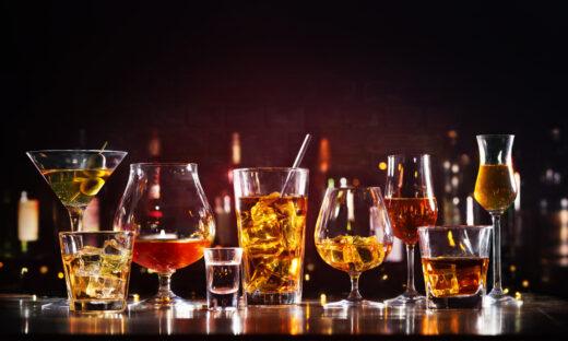 Assortment of hard strong alcoholic drinks and spirits in glasses on bar counter