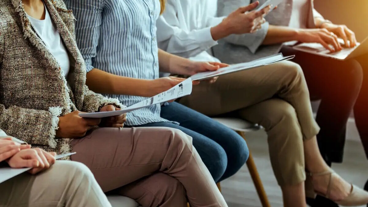 business people sitting on chairs in waiting room