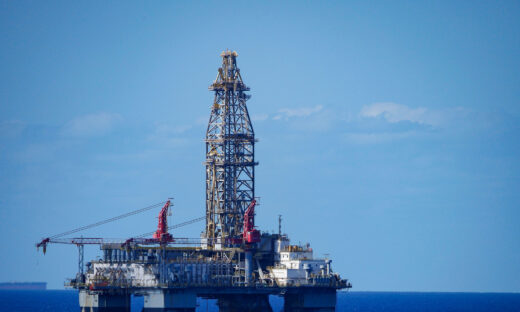 A large offshore oil rig in the middle of a vast expanse of ocean