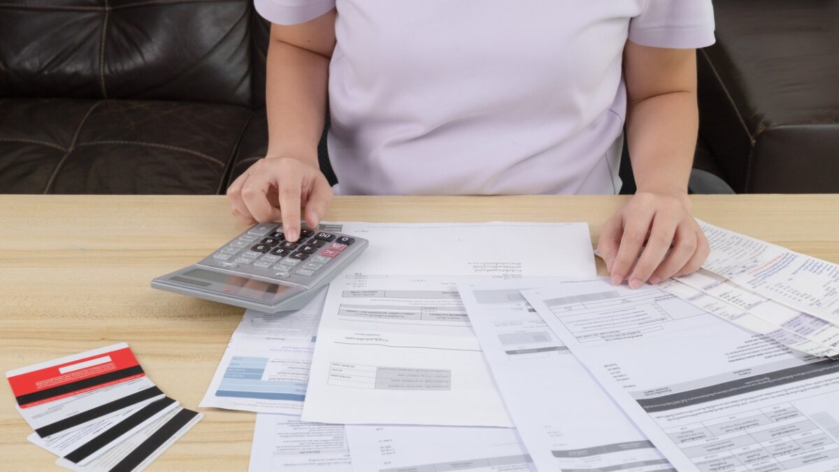 A woman pressing the calculator for calculate the money for her dept