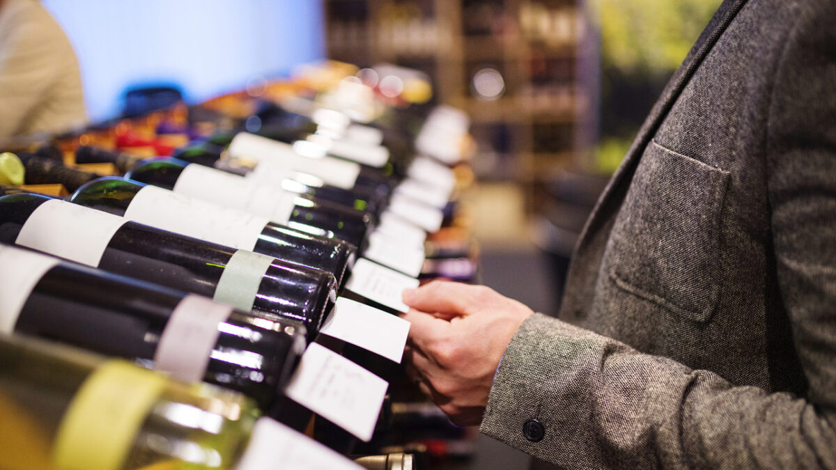 Unrecognizable young man in a wine shop choosing a wine