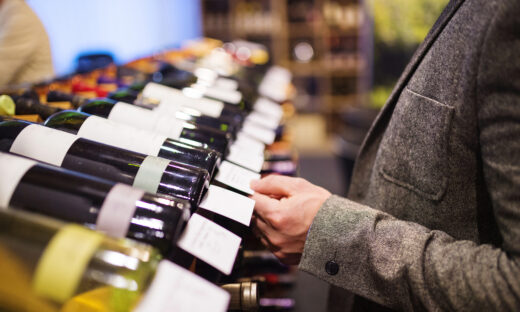 Unrecognizable young man in a wine shop choosing a wine