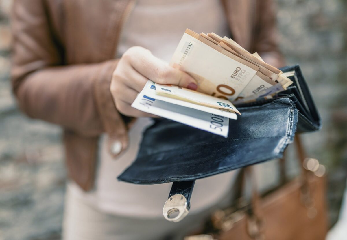 Woman holding wallet with euro money