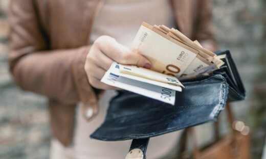 Woman holding wallet with euro money