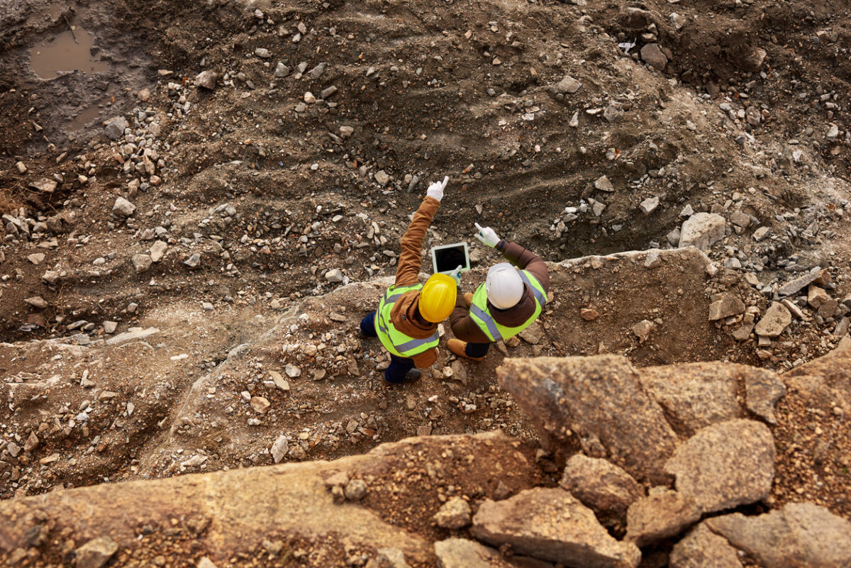 industrial workers wearing reflective jackets standing on mining worksite outdoors