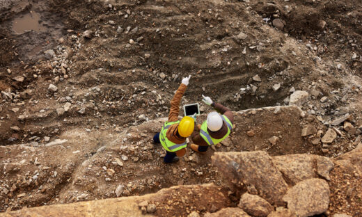 industrial workers wearing reflective jackets standing on mining worksite outdoors