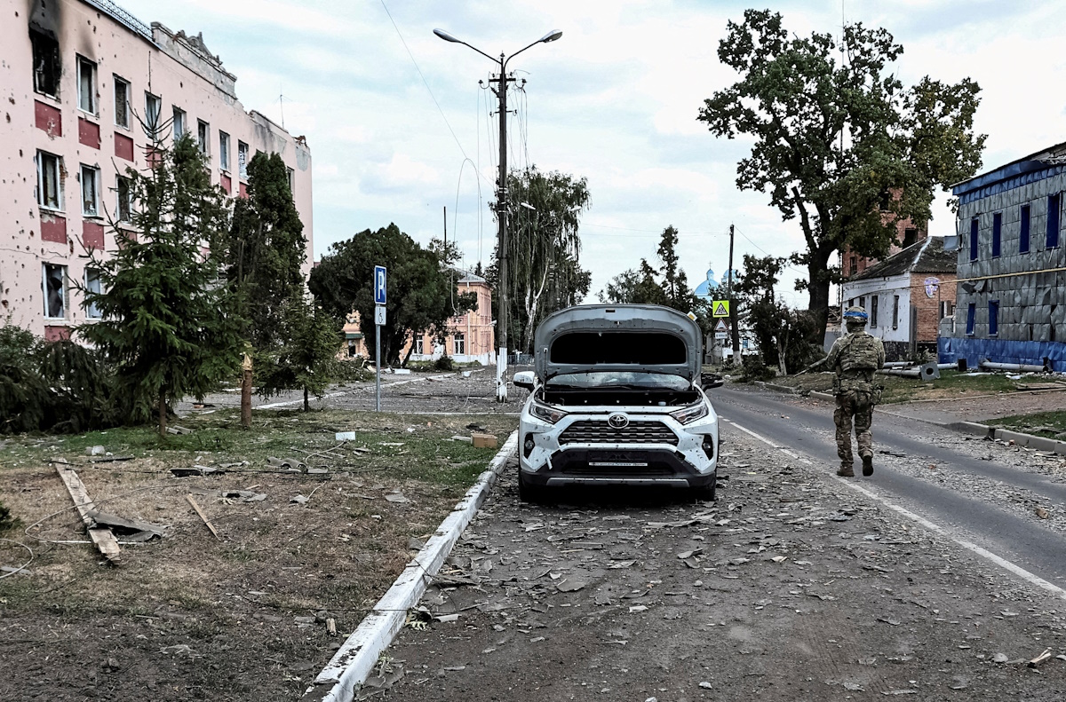 Ουκρανός στρατιώτης περιπολεί σε δρόμο δίπλα σε κτίρια που υπέστησαν ζημιές κατά τη διάρκεια πρόσφατων μαχών μεταξύ ουκρανικών και ρωσικών δυνάμεων στην ελεγχόμενη από την Ουκρανία πόλη Sudzha στην περιοχή Κουρσκ