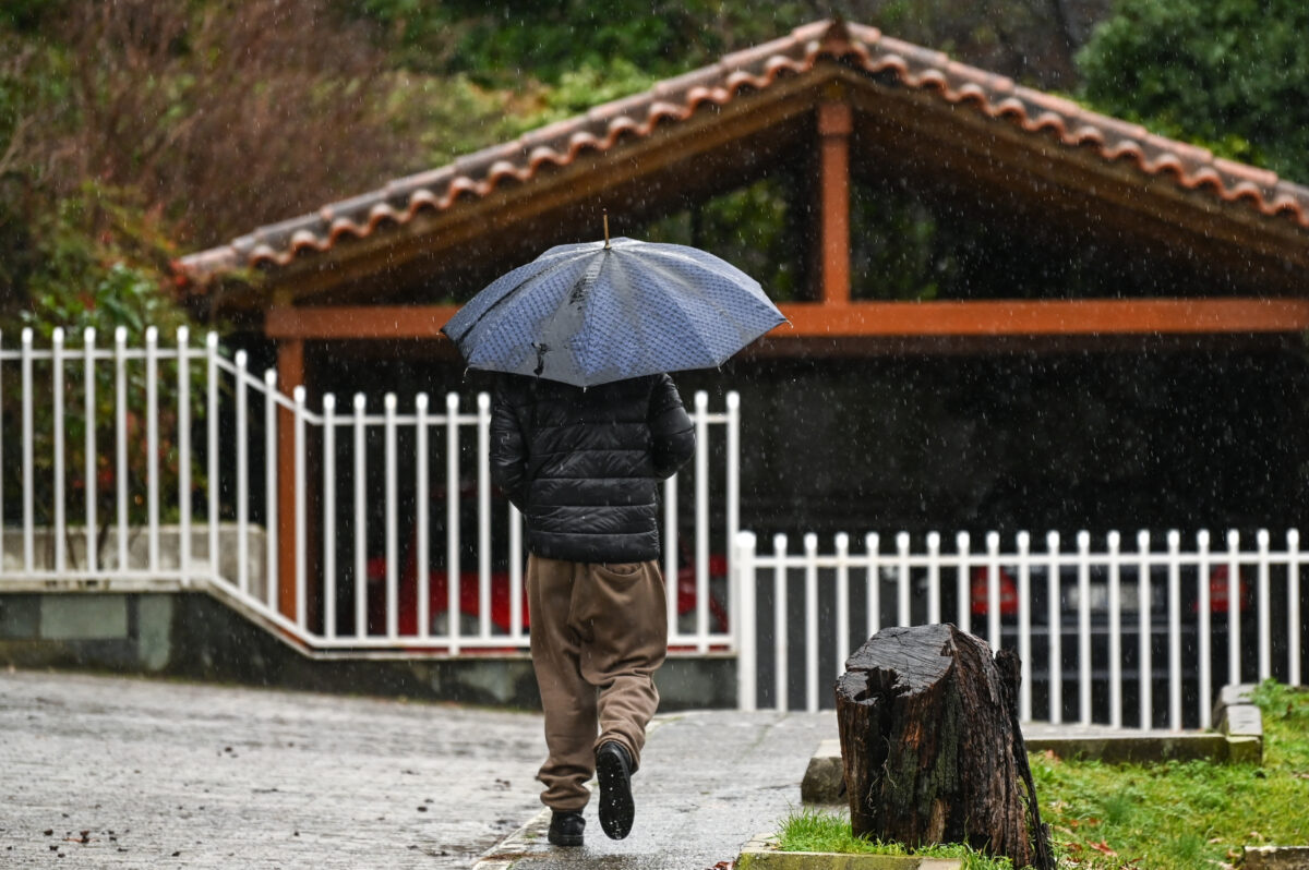 Άνδρας με ομπρέλα στη βροχή