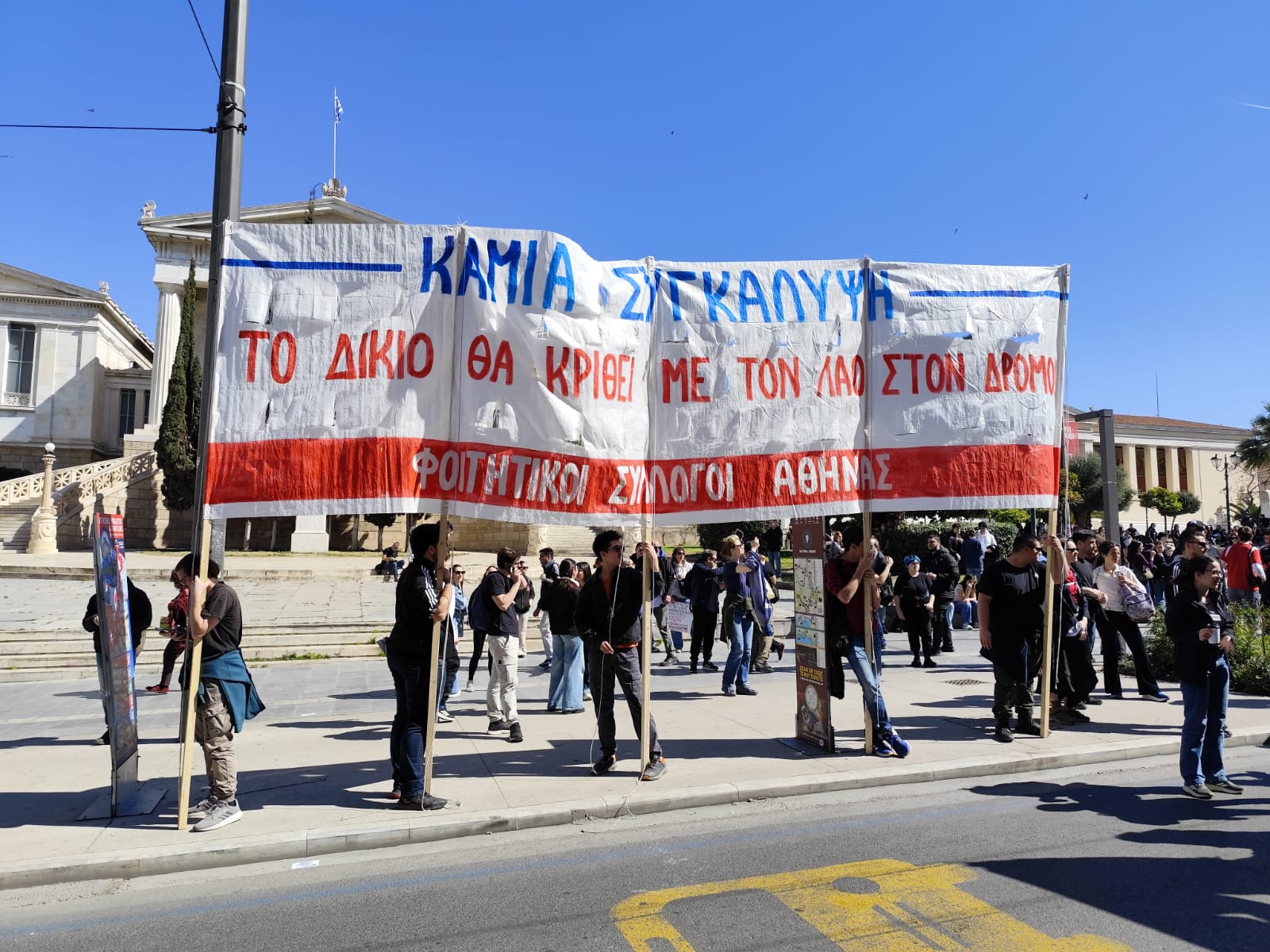 Μέλη φοιτητικών συλλόγων με πανό για τα Τέμπη στα Προπύλαια