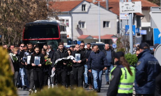 Συγγενείς των θυμάτων κρατούν λουλούδια και φωτογραφιές των δικών τους ανθρώπων που έχασαν τη ζωή τους στην τραγωδία