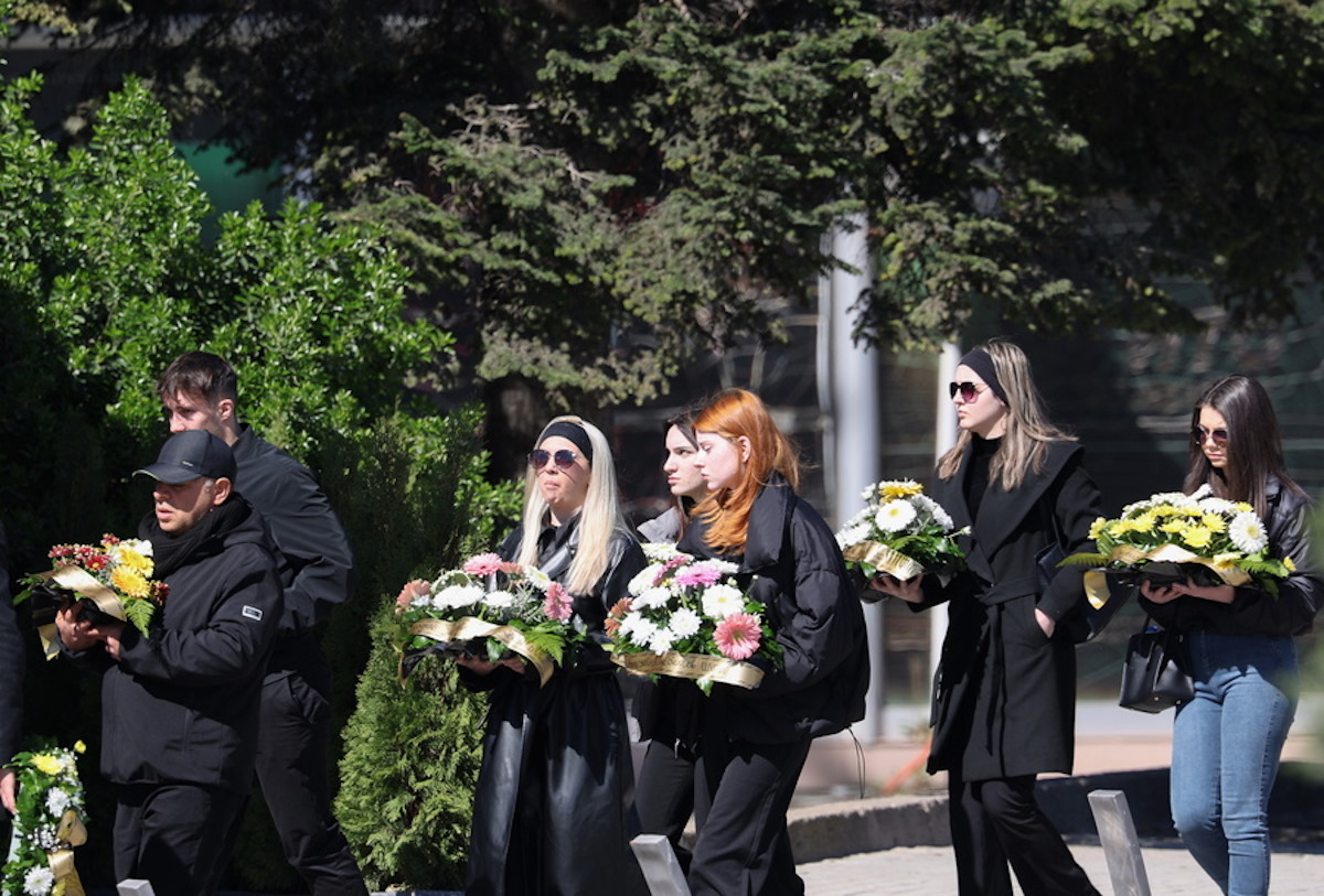 Συγγενείς θυμάτων κρατούν λουλούδια στα χέρια